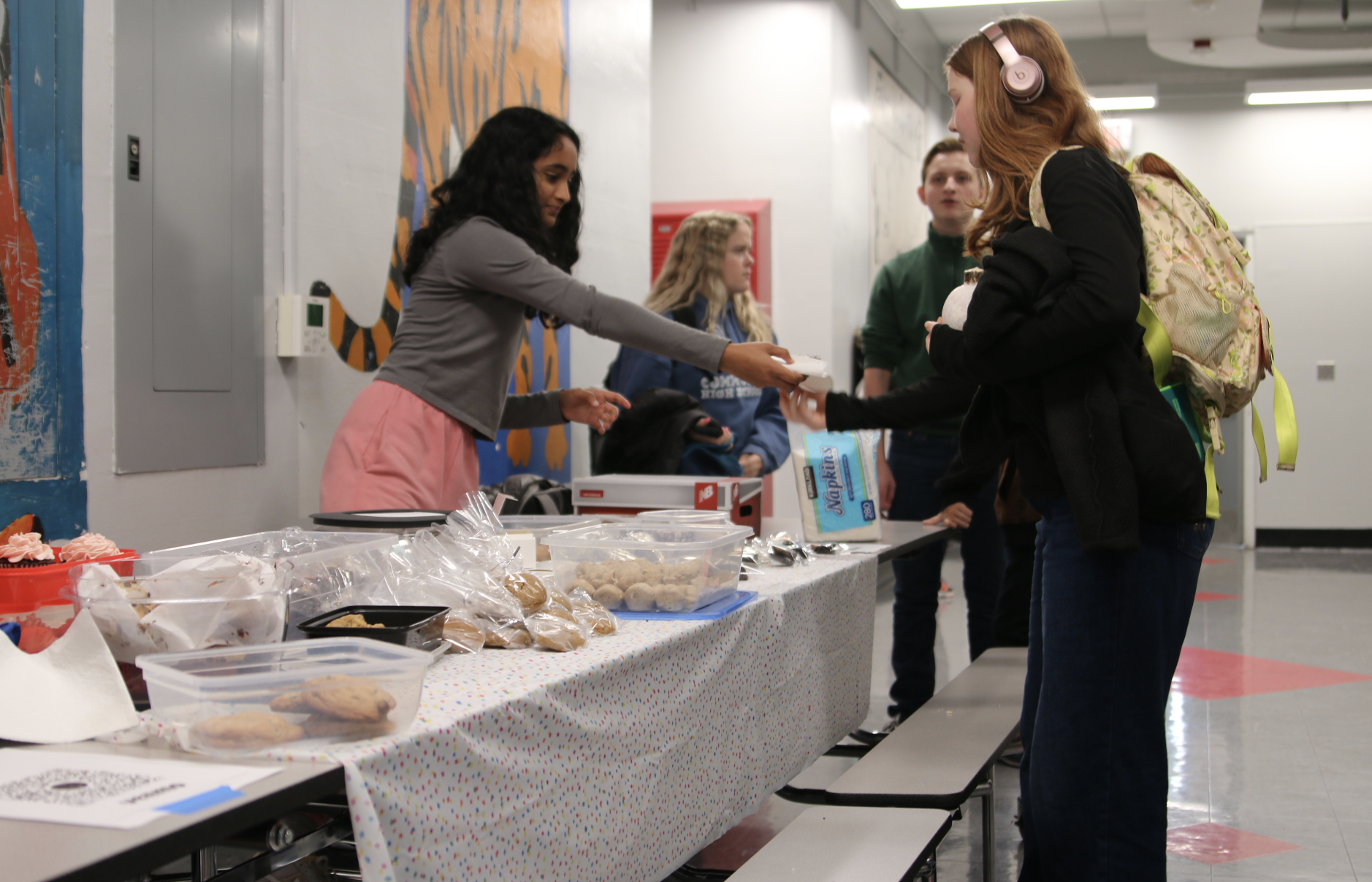 Qu forumettes meet in the third-floor hallway to sell baked goods for food gatherers. After the success of the bake sale last year, the forum knew they wanted to do the same thing this year. It was so much fun to sell the pastries, Janaki Nallamothu said. I hope we get to do it again